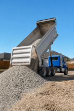 Dump truck unloading gravel at a construction site