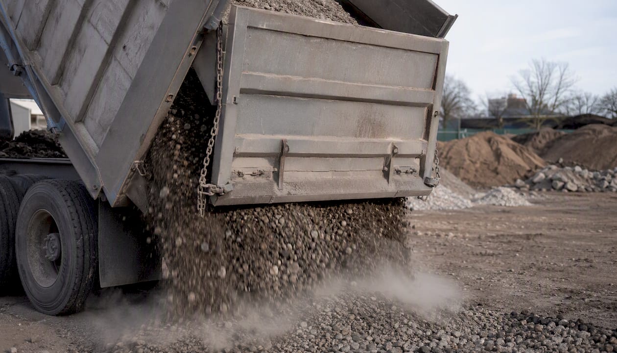 Dump truck tailgate open with chain controlling gravel flow