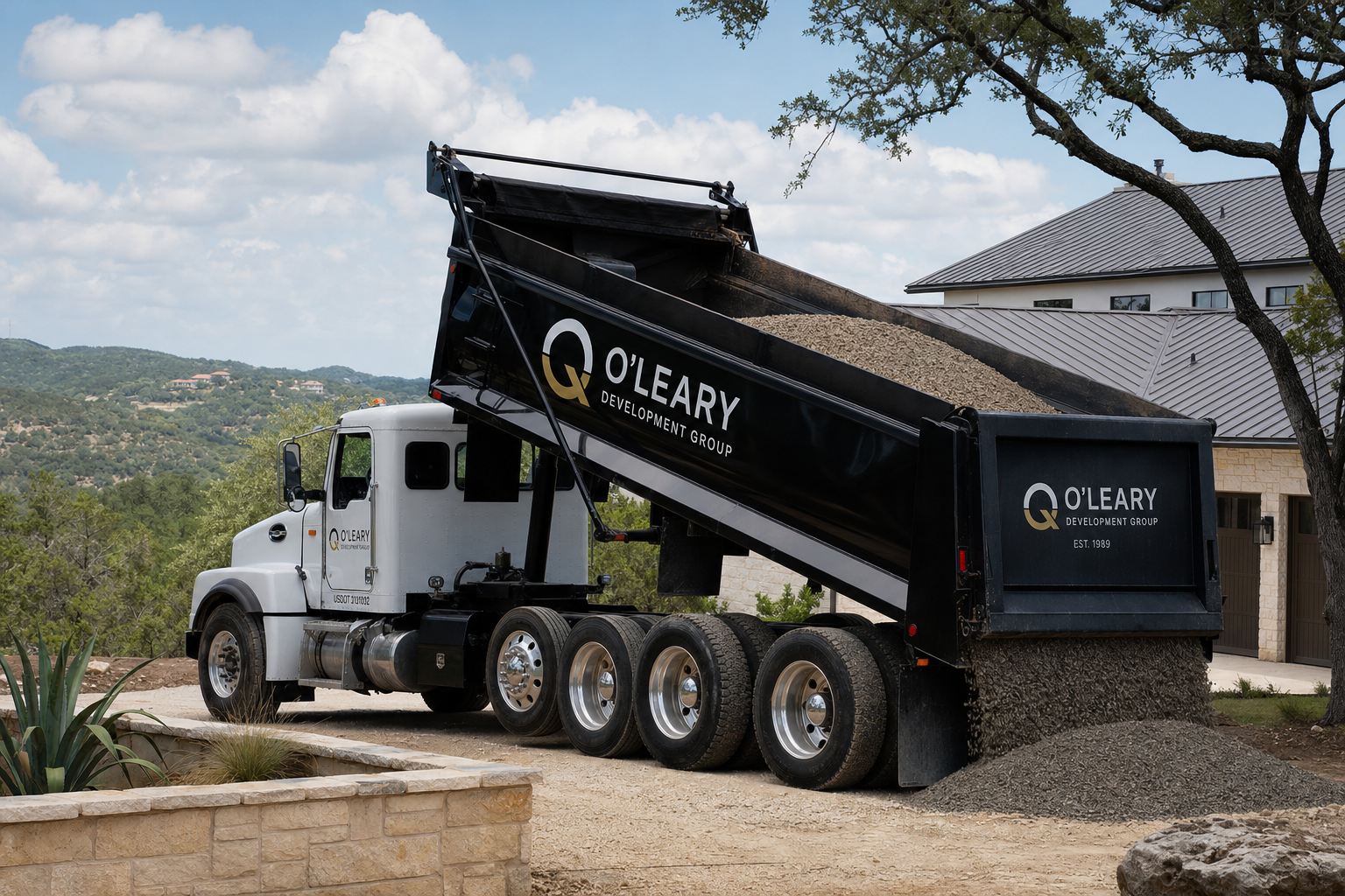 O'Leary Development Group dump truck delivering road base material to a residential driveway project in the San Antonio Hill Country